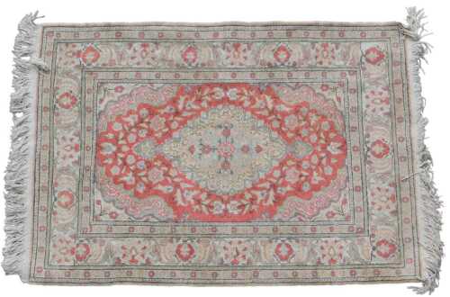 A Persian mercerised cotton rug, with a central medallion, in pale blue, on a red ground, one...