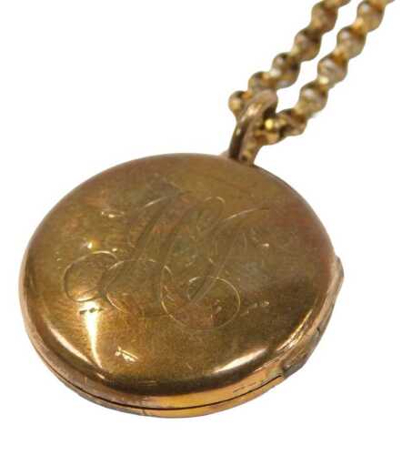 A late 19thC gold plated locket pendant and chain, the circular locket with scroll engraving, on...