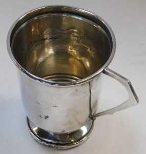 A George VI silver beaker, with lower banded decoration and angular handle, raised on a circular... - 2