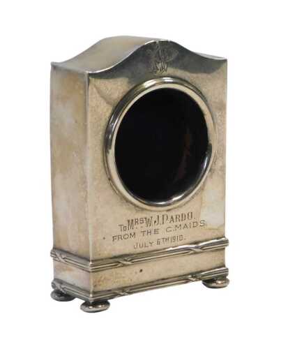 A George V silver mounted pocket watch case, of arched form, with circular aperture, engraved...