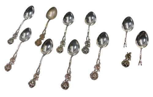 An associated set of eight Continental white metal coffee spoons, each pierced handle decorated...