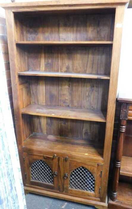 An Indian hardwood bookcase, with cupboard doors below, three shelves over two doors, 190cm high,...