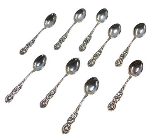 A set of nine Continental white metal coffee spoons, each with a pierced handle decorated with...