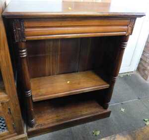 A mahogany open bookcase, of two shelves, with carved decoration, raised on plinth base, 121cm...