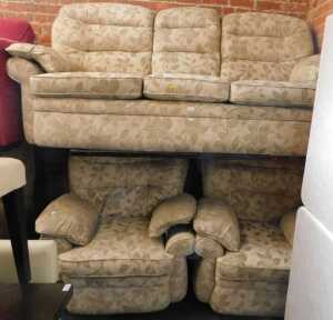 A lounge suite, comprising a three seater sofa, and two armchairs, upholstered in a light brown...