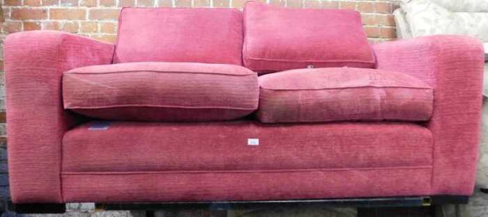 A red upholstered two seater sofa by Delcor.