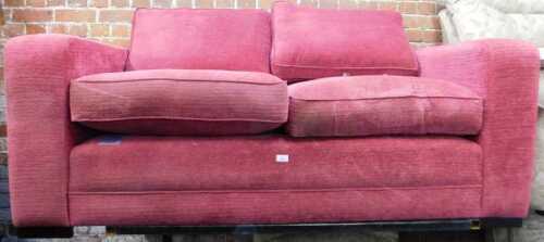 A red upholstered two seater sofa by Delcor.