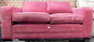 A red upholstered two seater sofa by Delcor.