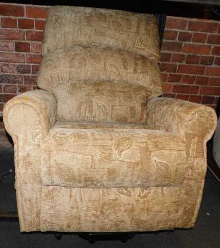 A rise and fall electrically operated armchair, upholstered in a light brown fabric with foliate...