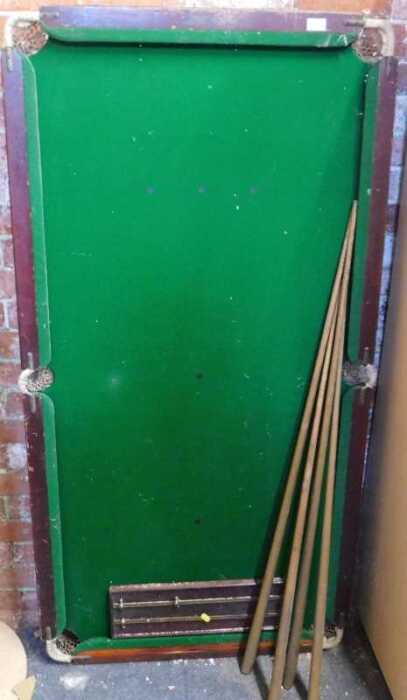 A quarter size tabletop snooker table, with cues and scoreboard.