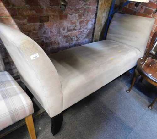 A beige upholstered double ended scroll arms chaise longue bench, with dark wooden tapering legs.