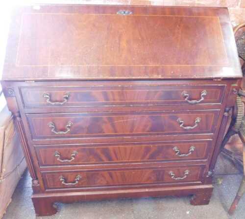 A mahogany veneered fall front bureau, fall over four long drawers, flanked by reeded columns,...