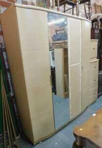 An Alstons Synergy bedroom suite, comprising a four-door wardrobe with a mirrored centre section,...