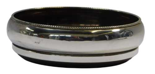An Elizabeth II silver mounted wine coaster, with a beaded border and turned oak base,...