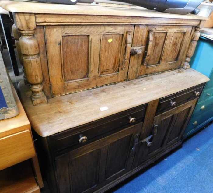 A light elm and beech finished court cupboard, with two doors to top over two drawers above two...