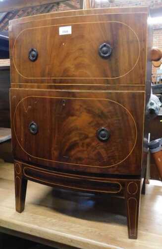 A Georgian Revival mahogany commode, with boxwood line inlay, the fabric cupboard lid opening to...