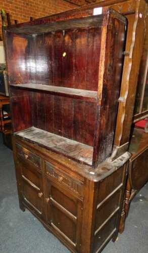 A dark oak dresser, with a plate rack over two drawers above two cupboard doors, raised on...
