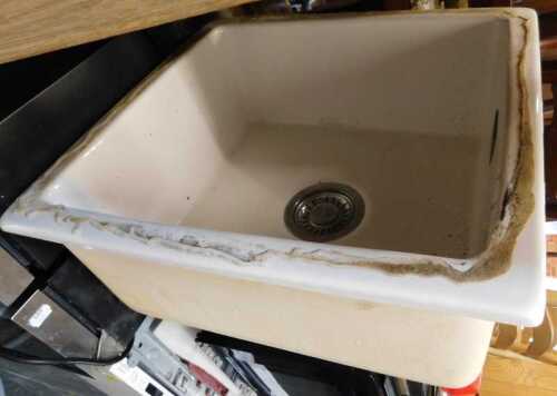 A ceramic sink, square in form, and a mixer kitchen sink tap.