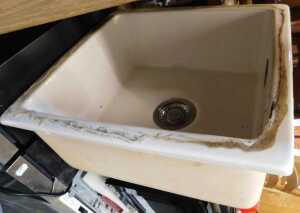A ceramic sink, square in form, and a mixer kitchen sink tap.