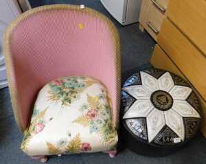 A leatherette topped Indian style pouffe, circular in form, and a pink finished Lloyd Loom style...