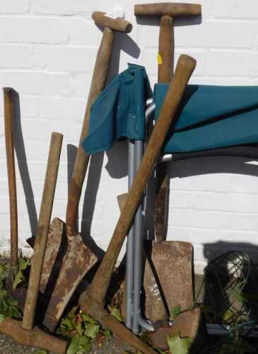 Garden tools, to include a pick axe, lump hammer, large axe, large spades, a garden chair.
