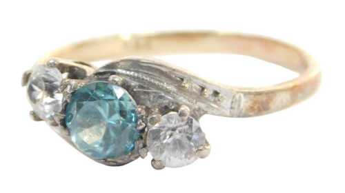 A three stone twist ring, set with blue and white paste stones, in a raised claw basket setting,...