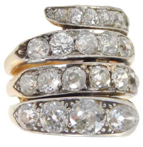 A Victorian diamond and ruby set snake ring, set with old mine cut diamonds over four graduated...
