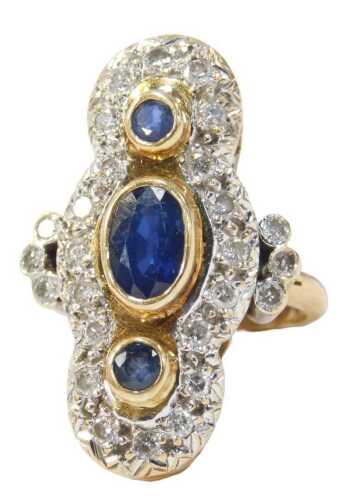 A sapphire and diamond finger ring, the large ring head centre set with oval and round brilliant...