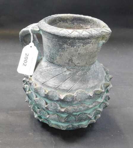 A ceramic jug, with single handle, and ribbed decoration.