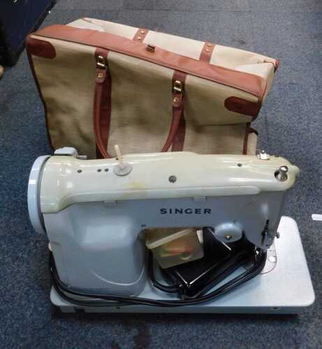 A cased Singer electric sewing machine.