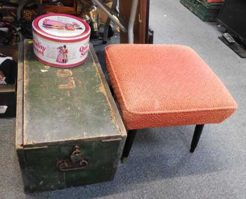 A stool, wooden trunk, and a Quality Street tin.