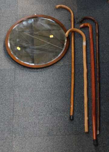 Four walking sticks, of various design and size, a circular wooden framed bevelled mirror....