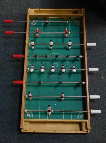 A tabletop babyfoot, with red and white teams, 7cm high, 96cm long, 44cm wide. (under 1 table)