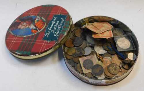 A circular tin, with lid, containing a quantity of British, foreign and commemorative coinage...