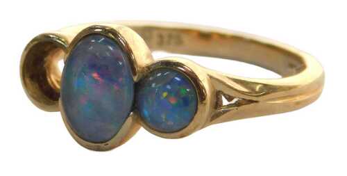 A black opal dress ring, the three stone graduated ring, set with two opals (one missing), in a...