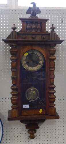 A vintage wooden cased wall clock, carved with eagle to top, Roman numerals to chapter ring,...