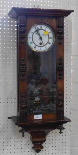 A vintage wall clock, with Roman numerals to enamel dial, carved pediment to top, and pendulum...