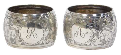 A pair of late Victorian silver napkin rings, each engraved with flower heads and leaves,...