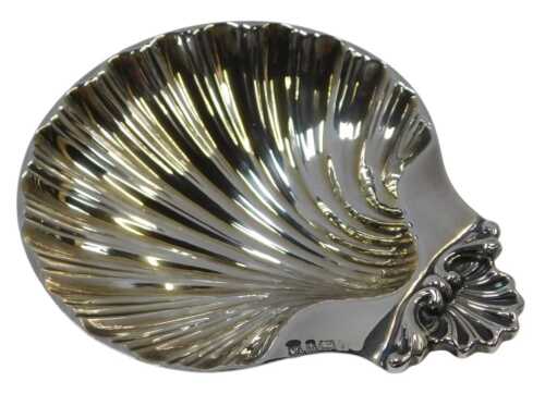 An Elizabeth II silver shell shaped butter dish, raised on three shell feet, Birmingham 2000,...