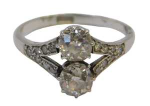An Art Deco diamond ring, set with two old round-cut stones of 5.2mm diameter each, split shoulders set with seven tiny stones of 1mm, shank stamped PLAT., size N-O, 4g all in, in a Garrard & Co articulated box.