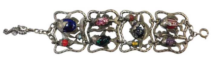 A contemporary four-link bracelet, white metal and coloured art glass, cast as open panels of...
