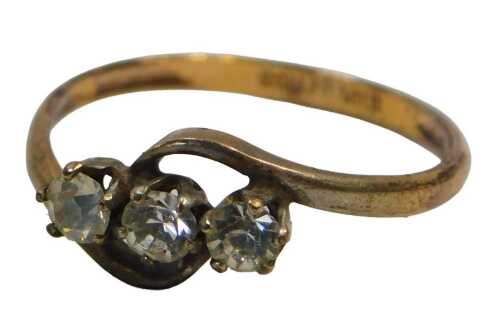 A three stone dress ring, set with three paste stones, on twisted design, on a rolled gold band,...
