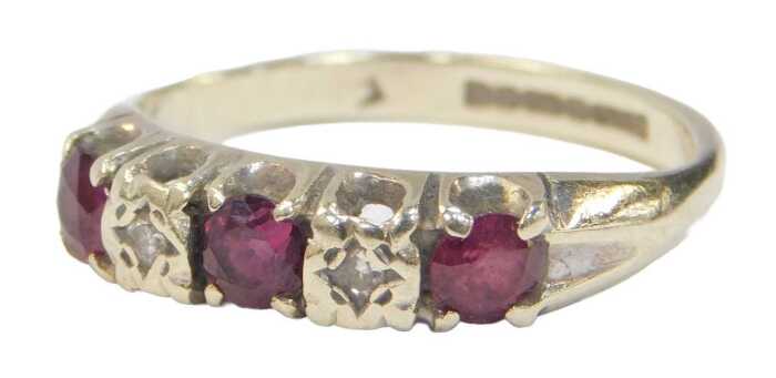 A 9ct white gold ruby and diamond half hoop dress ring, set with three round brilliant cut...
