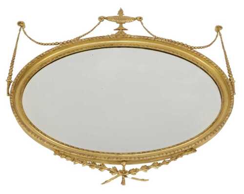 A 19thC Neo Classical style gilt wood mirror, of oval form with a gadrooned border, surmounted...