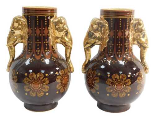 A pair of late 19thC pottery vases, each of bottle form with gilt elephant-head handles, the...