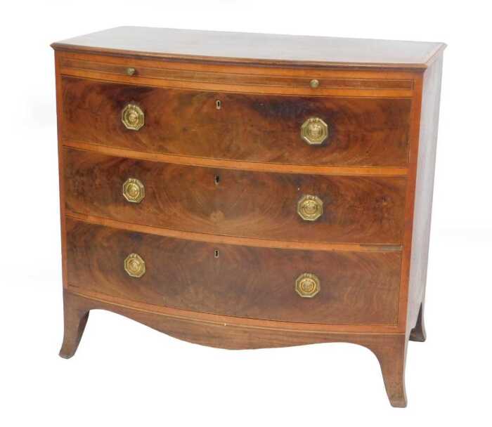 A George III Sheraton mahogany bow front bachelor's chest, with satinwood banded top, brushing...