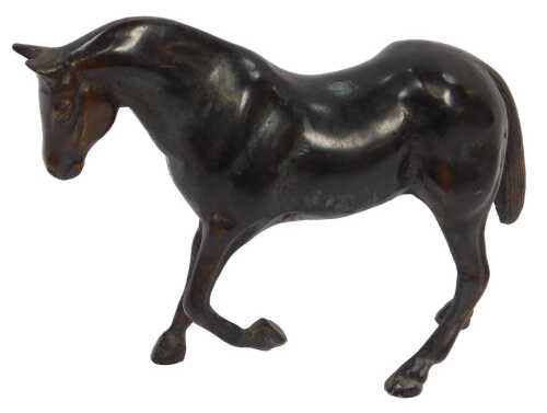 A late 19thC cast bronze sculpture of a standing horse, with one front leg raised, 12.5cm high.