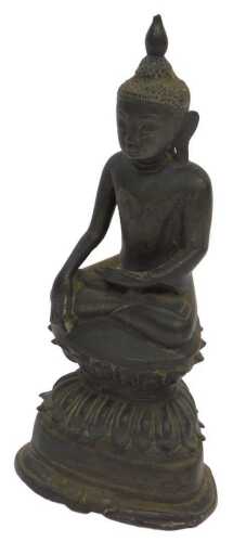 An 18th/19thC Burmese bronze seated figure of Buddha, in traditional pose and style, 22cm high.