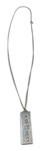 A silver ingot pendant and chain, the ingot 1977, 4cm high, on fine link chain, 50cm long, 22.2g.