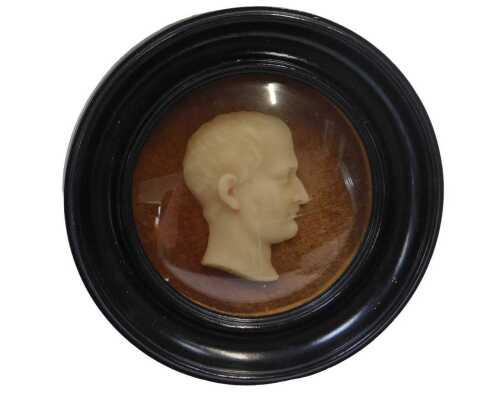 A 19thC wax profile, possibly a Roman Emperor, on a later brown velvet backing with an ebonised...